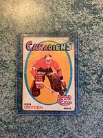 Front view of Ken Dryden rookie card showing creases and damage with missing top corner