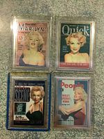 Four Marilyn Monroe hologram collector cards in plastic sleeves, each depicting different magazine covers and poses.