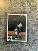 Michael Jordan baseball card in a plastic protective sleeve, showing Jordan in black and white baseball uniform fielding.