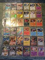 Top-down view of one page of Pokémon holographic cards featuring multiple EX, GX and Trainer cards in sleeves