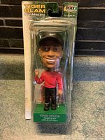 Front view of Tiger Woods bobble head in original PlayMakers packaging showing figure and card clearly.