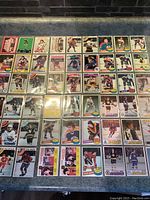 Photo of page one of vintage hockey cards with various players, team logos, and a range of card designs