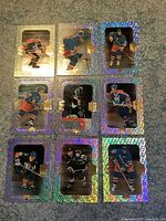 Nine holographic Wayne Gretzky hockey cards arranged in three rows and three columns, featuring different action poses and uniforms in good condition.