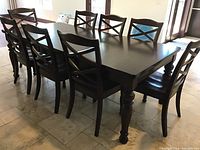 Full view of dark brown dining table set with eight chairs