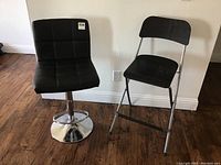 Pair of black chairs: leather adjustable stool and wooden folding chair