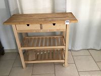 Full view of larger butcher block table cart showing two drawers, two shelves and wheels.