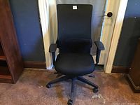 Front view of the black high back office chair showing the seat, backrest, and armrests.