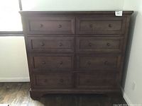 Front view of eight-drawer dresser in matching brown wood finish