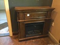 Front view of the Twin Star electric fireplace, showing wooden mantel and electric firebox insert.