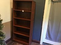 Full view of the tall dark wood bookcase showing six shelves.