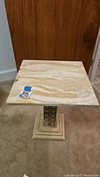 Image showing square marble tabletop with natural beige and cream marble pattern.