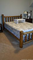 Side view of wooden bed frame with mattress and white tray on top