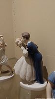 Porcelain figurine of a dancing couple with man in blue suit and woman in white dress