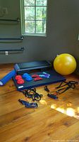 Overview showing fitness step platform, exercise mat, fitness harness bands, balance balls, and yellow exercise ball