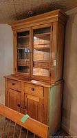 Full front view of two-piece hutch showing upper glass doors, lower drawers and doors.