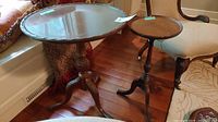 Two wooden pedestal tables shown together: larger with pie crust edge and smaller round topped table.