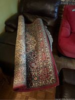 Rolled-up area rug on sofa showing portion of pattern
