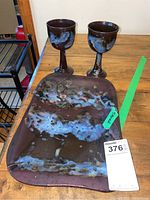 Photo showing the two stemmed pottery cups and the rectangular pottery tray, all featuring brown color with blue and white glaze designs.