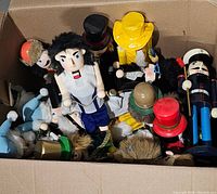 Medium Home Depot cardboard box filled with numerous wooden nutcracker figurines in different costumes and colors.