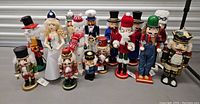 Photo showing 12 nutcracker figurines including bride, snowman, traditional soldiers, and unique character styles.