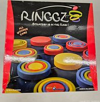 Front box cover displaying the Ringgz logo, tagline, and wooden game rings in various colors.
