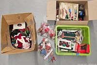 Boxes containing vintage Christmas decorations, ornaments, bubble light sets, and figurines with some items still in packaging.