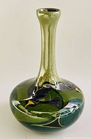 Side view showing the hand painted bird motif on the main bulbous body and narrow neck of the ceramic vase.