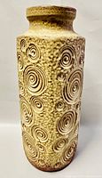 Front view of tall textured floor vase with spiral circular patterns in beige and brown glaze.