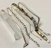 Five sterling silver bracelets displayed slanted, showing different chain types and inlaid rectangular sections.