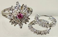 Front angle showing detailed floral design of ring and crystal-embedded hoop earrings.