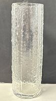Front view of the textured clear glass cylindrical vase showing surface detail and shape.