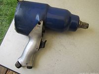 Photo of the Unipower 3/4 inch pneumatic impact wrench showing the ergonomic handle, trigger, blue rounded top section, and air inlet connection fitting at the bottom.