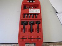Top view of the open red plastic case showing drill bits and accessories organized in molded slots.