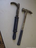 Photo showing Eastwing framing hammer and gray nail puller on a white surface.