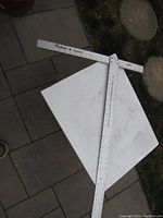 Photo showing the full drywall square lying on pavement and a white board, displaying the brand name Robart Canada and measurement markings.