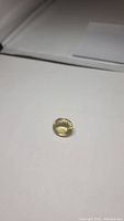 Natural oval cut lemon citrine gemstone placed on white background, showing its bright yellow color and clarity.