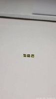 Three small square cut apple green peridots aligned horizontally on a white background, showing clarity and color