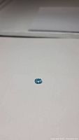 Oval Swiss Blue Topaz gemstone on white background showing color and cut