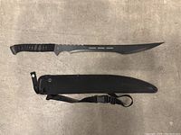 Large tactical blade and black nylon sheath with strap and buckle.