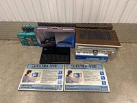 Full lot including Kenwood receiver, Ultra-Vue filters, Nortek DVD player box, Daytek PB71 box, and Metaltech lock box on floor.