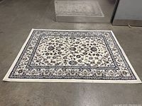 Carpet laid out flat on a concrete floor to show full design and size.