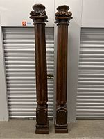 Two tall wooden pillars standing side-by-side against storage unit door.