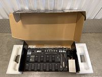 Unit inside original box with foam inserts, power adapter visible