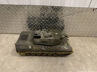 Top view of remote control tank model showing turret, tracks, and paint wear.