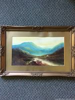 Full view of the framed landscape painting showing the entire artwork and ornate gold-tone frame.