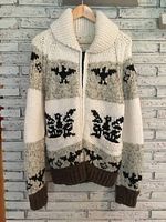 Front view of wool sweater on hanger showing shawl collar, full zipper, bird motif on cream and gray stripes, brown ribbed hem and cuffs.
