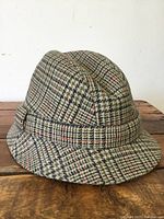 Side angle view of vintage Scottish tweed gentlemen's hat showing textured wool fabric and classic check pattern.