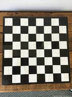 Top view of marble inlay chess board showing alternating black and white squares with natural marble veining on white squares.