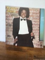 Front cover of the Michael Jackson 'Off the Wall' vinyl LP showing Michael Jackson in a tuxedo against a brick wall.