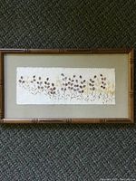 Full view of vintage pressed floral framed picture showing flowers on textured paper and wooden frame.